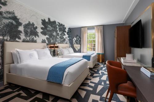 The Carolina Inn, a Destination by Hyatt Hotel في تشابل هيل: غرفة الفندق بسرير كبير ومكتب