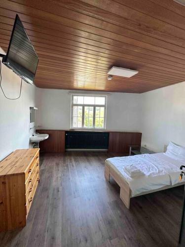 1 dormitorio con cama y techo de madera en 220qm2*10 Einzelzimmer*2Bäder*2WCs*Monteurzimmer Ludwigsburg Heilbronn Backnang, en Oberstenfeld