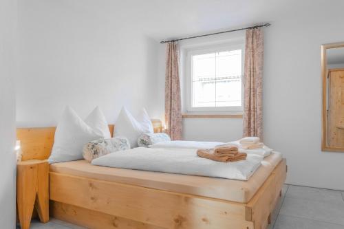 een slaapkamer met een houten bed en een raam bij Landhaus Plainer in Innsbruck