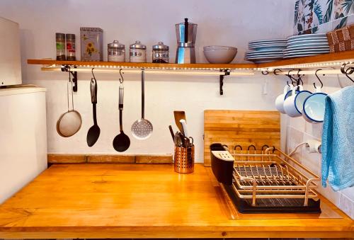 a kitchen with a wooden counter top with utensils at La Casita del Cactus - Casa de campo con piscina in Alcalá de Guadaira