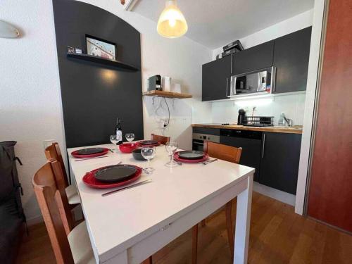 a kitchen with a table with red plates on it at La Mongie T3 Duplex 8 personnes vue sur les pistes in Bagnères-de-Bigorre