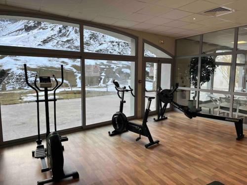 a gym with treadmills and exercise bikes in a room at La Mongie T3 Duplex 8 personnes vue sur les pistes in Bagnères-de-Bigorre