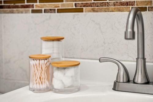 a kitchen sink with two glass containers with wooden tops at Charming Home In Heart of City With King Size Bed! in Philadelphia