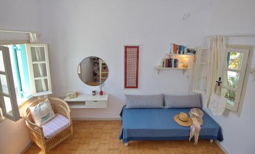 een slaapkamer met een bed, een stoel en een spiegel bij Casa Kalypso in Steni Vala Alonissos