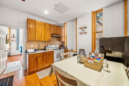 a kitchen with wooden cabinets and a table in a room at Charming Home In Heart of City With King Size Bed! in Philadelphia