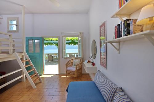 a living room with a blue couch and a staircase at Casa Kalypso in Steni Vala Alonissos