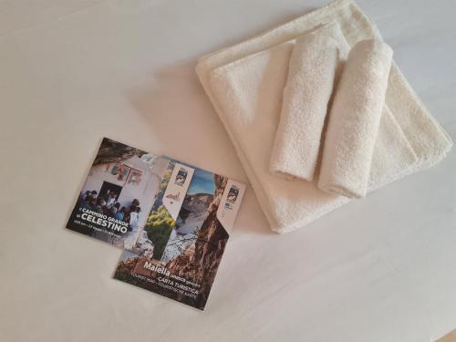 a book and two pamphlets next to a towel at Casa vacanza da Anna 2 in Pratola Peligna