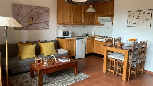 a kitchen and a living room with a couch and a table at Al Viento, Alojamiento & Turismo Rural Prádena del Rincón in Prádena del Rincón