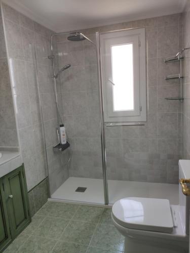 La salle de bains est pourvue d'une douche, de toilettes et d'une fenêtre. dans l'établissement Apartamento en primera línea de playa, con vistas a la playa y con wifi, à Roquetas de Mar