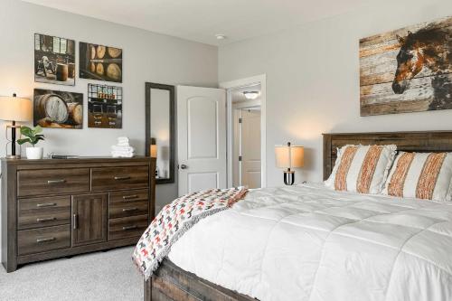 a bedroom with a large bed and a wooden dresser at Shelbyville Farmhouse with Hot Tub, Fire Pit and Grill in Shelbyville