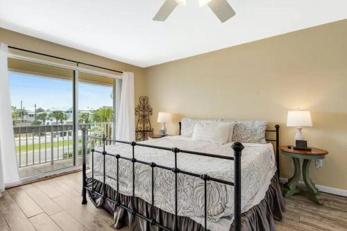 a bedroom with a bed and a large window at Flip Side Oasis Beach House in Pensacola Beach