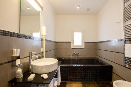a bathroom with a sink and a bath tub at De Stefano Palace Luxury Hotel in Ragusa