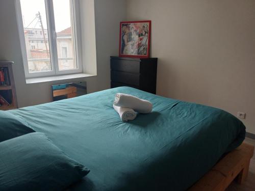 a bed with a towel sitting on top of it at Le grenier à sel, Chaleureux 2 Chambres-Centre-Gare in Reims