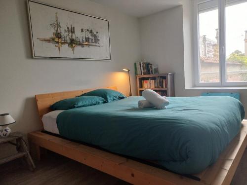 a bedroom with a large bed with a blue comforter at Le grenier à sel, Chaleureux 2 Chambres-Centre-Gare in Reims
