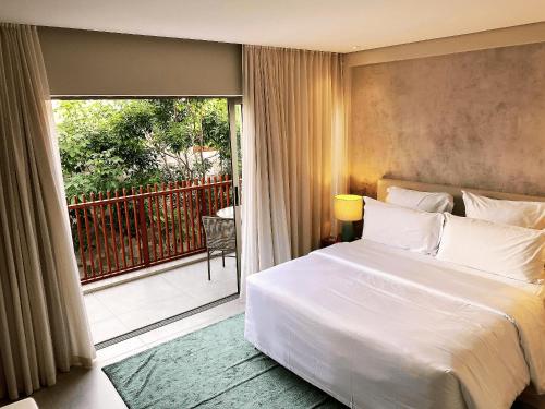 um quarto com uma cama grande e uma varanda em Flat Île de Pipa Varanda - By Almare em Pipa