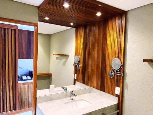 um banheiro com uma pia e um espelho grande em Flat Île de Pipa Varanda - By Almare em Pipa