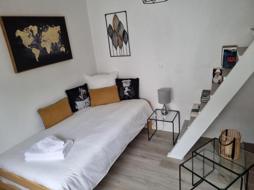 une petite chambre avec un lit et un escalier dans l'établissement Maison ville dans une voie privée, à Saint-Ouen