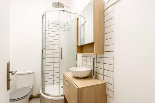 La salle de bains est pourvue d'un lavabo, de toilettes et d'une douche. dans l'établissement Studio proche plage, à Sainte-Adresse