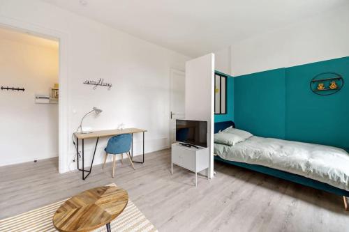 a bedroom with a bed and a desk and a table at Studio proche plage in Sainte-Adresse