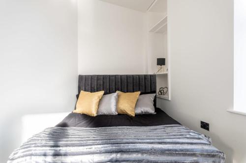 Schlafzimmer mit einem Bett mit grauem Kopfteil in der Unterkunft Stylish Central Studio Apartment Modern Luxury in Brighton & Hove