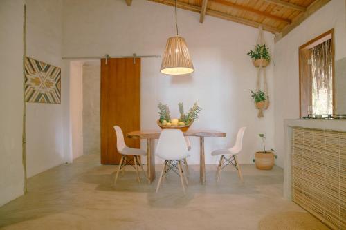 a dining room with a table and white chairs at Ventos Morere Hotel & Beach Club in Ilha de Boipeba