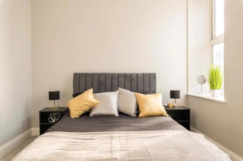 een slaapkamer met een groot bed met kussens bij Stunning Central Apartment In Heart Of Brighton in Brighton & Hove