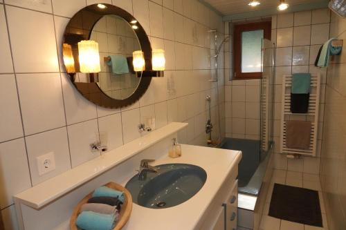 a bathroom with a sink and a mirror and a shower at Appart Mona in Ramsau im Zillertal