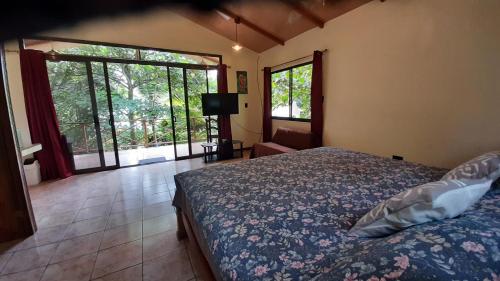 1 dormitorio con 1 cama y puerta corredera de cristal en Casa Martina, en Cahuita