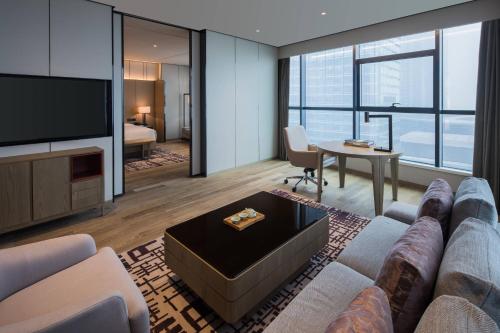 a living room with a couch and a tv at Chengdu Marriott Hotel Financial Centre in Chengdu