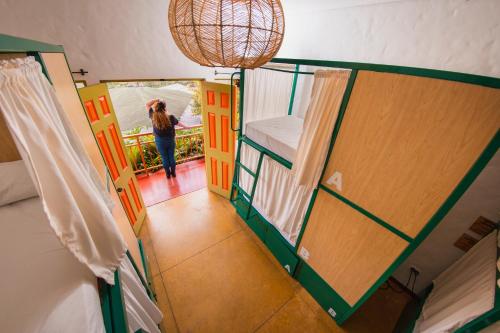 Viajero Salento Hostel في سالنتو: امرأة تمشي في ممر غرفة مع باب