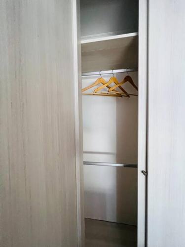 a closet with a door open with hangers at Departamento en Iquique in Iquique