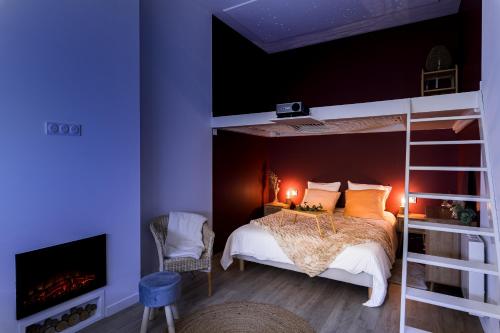 a bedroom with a bunk bed and a fireplace at Suite Évasion Céleste à Saint-Étienne in Saint-Étienne