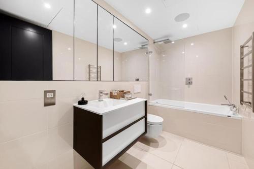 a bathroom with a sink and a toilet and a tub at Battersea Luxury Apartment, Private, Independent Entrance, Central in London