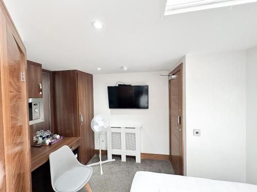ein Schlafzimmer mit einem Bett und einem TV an der Wand in der Unterkunft 205 Earls Court Rooms in London