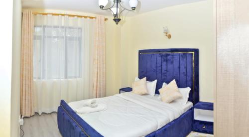 ein Schlafzimmer mit einem blauen Bett und einem Fenster in der Unterkunft Sandalwood Garden in Nairobi