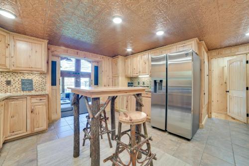 a kitchen with wooden cabinets and a stainless steel refrigerator at Lakefront Kalkaska Cottage with Fire Pit! in Kalkaska