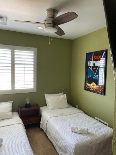 a bedroom with two beds and a ceiling fan at Private Room in Los Angeles LA with TV & WIFI & AC & View of Hollywood Sign & Private Fridge & Shared Kitchen!!! in Los Angeles