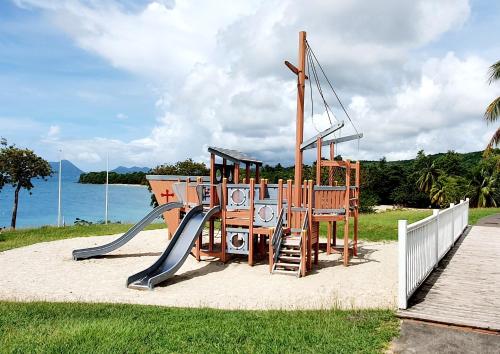 a playground with a slide in the sand near the water at TI OASIS Trinidad, Studio vue Mer à P&Vac village-club in Sainte-Luce
