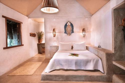 a bedroom with a bed with a white bedspread at Ventos Morere Hotel & Beach Club in Ilha de Boipeba