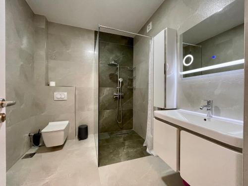 a bathroom with a shower and a sink and a toilet at Apartment with balcony in Gjakove
