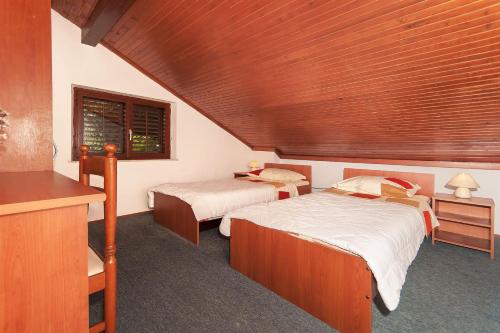 een slaapkamer met 2 bedden en een houten plafond bij Apartment Miho in Dubrovnik