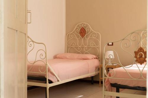 1 dormitorio con 2 camas con sábanas rosas en Maria's Bed - Intero alloggio accogliente, en Dorno