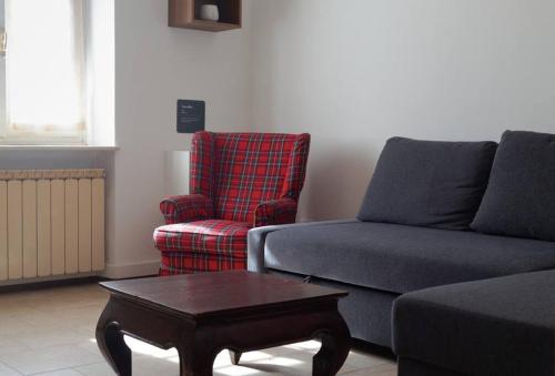 a living room with a couch and a chair and a coffee table at Maria's Bed - Intero alloggio accogliente in Dorno
