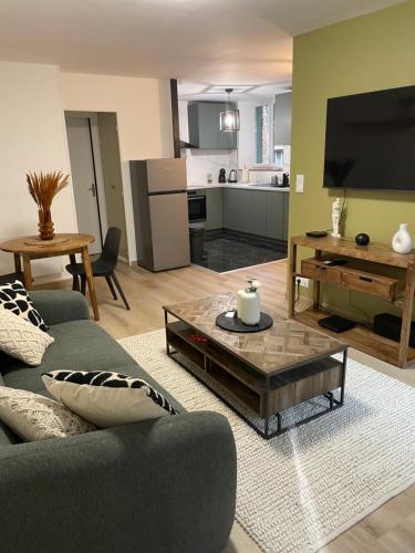 un salon avec un canapé et une table dans l'établissement MC Suite CMZ Métropolis PlaceDucale, à Charleville-Mézières