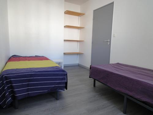 Habitación con 2 camas y armario con estanterías. en Zénith garden, en Estrasburgo