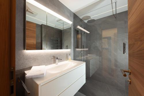 a bathroom with a sink and a mirror at New! Cozy, central apartment with a stunning view in St. Moritz