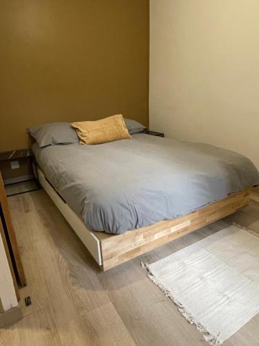 een bed met een houten frame in een slaapkamer bij MC Suite CMZ* in Charleville-Mézières