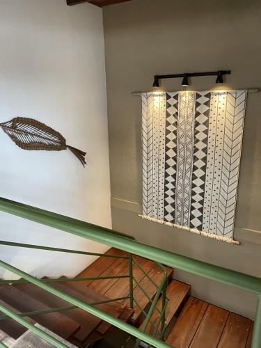 a room with a glass table and a feather on the wall at Ka'a Guest House in Ubatuba