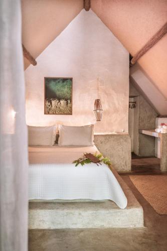 a bedroom with a bed with a painting on the wall at Ventos Morere Hotel & Beach Club in Ilha de Boipeba
