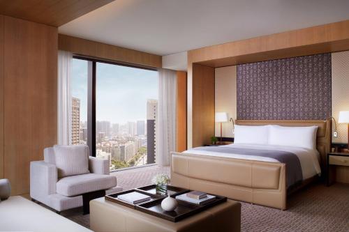 sypialnia z łóżkiem i krzesłem oraz dużym oknem w obiekcie The Ritz-Carlton, Xi'an w mieście Xi'an